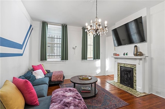 living room featuring a high end fireplace, dark wood-type flooring, and a notable chandelier