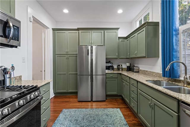 kitchen featuring green cabinets, sink, dark hardwood / wood-style floors, appliances with stainless steel finishes, and light stone counters