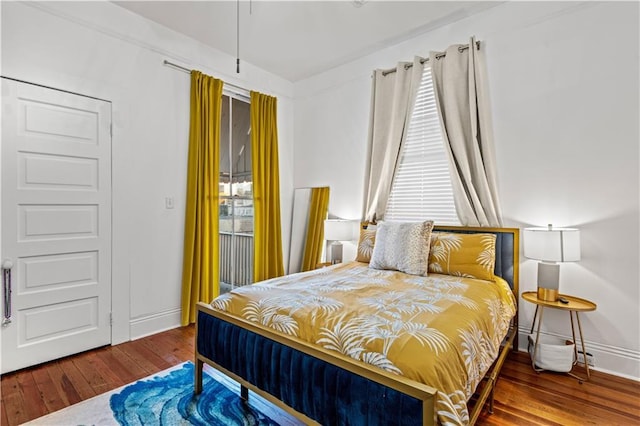 bedroom with multiple windows and hardwood / wood-style flooring