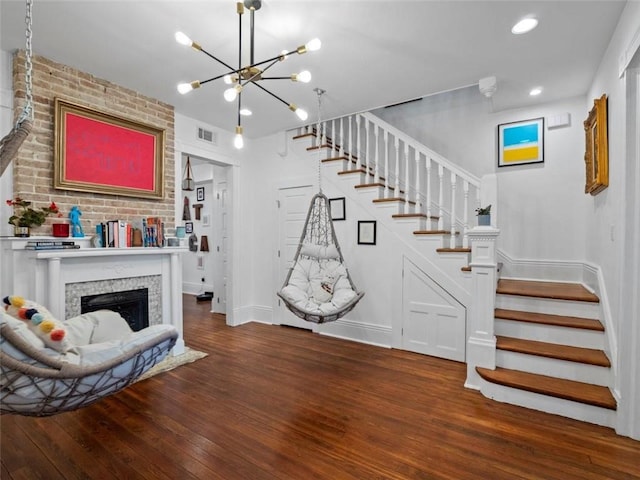 interior space featuring a chandelier, wood-type flooring, and a tiled fireplace