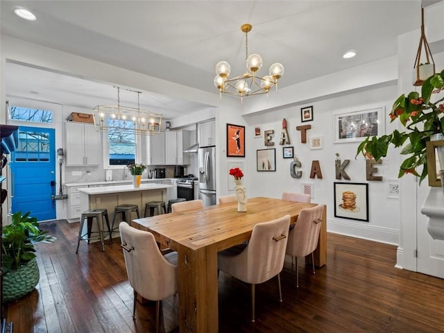 dining room with dark wood-type flooring and a chandelier