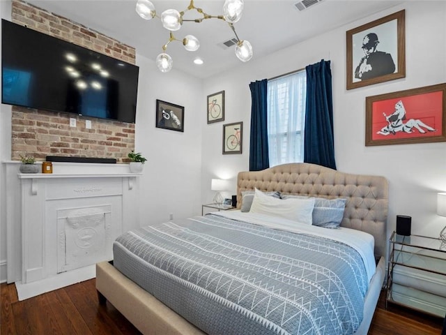 bedroom featuring a notable chandelier, dark hardwood / wood-style floors, and a fireplace