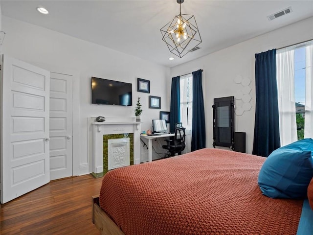 bedroom with wood-type flooring and an inviting chandelier