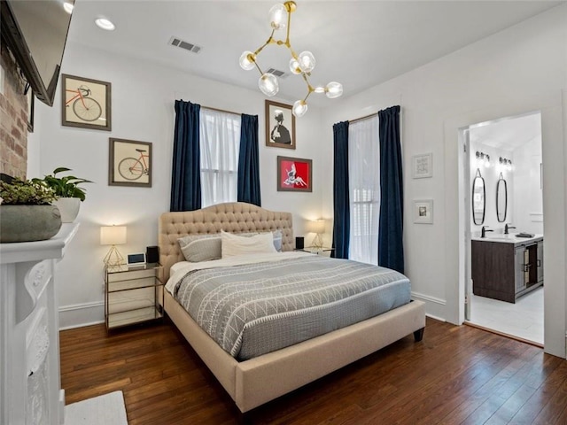 bedroom with a chandelier, dark hardwood / wood-style floors, and ensuite bathroom