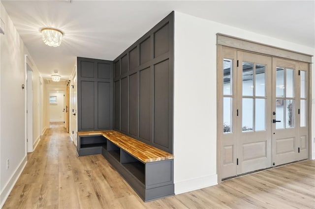 mudroom featuring plenty of natural light, french doors, and light hardwood / wood-style flooring