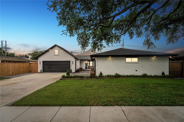 single story home featuring a garage and a lawn