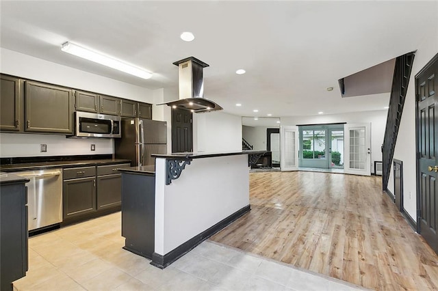 kitchen with stainless steel appliances, light hardwood / wood-style flooring, island exhaust hood, a breakfast bar, and a kitchen island