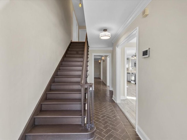 stairs with crown molding and ceiling fan