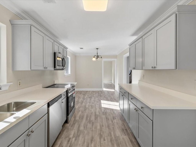 kitchen with stainless steel appliances, gray cabinets, and ornamental molding