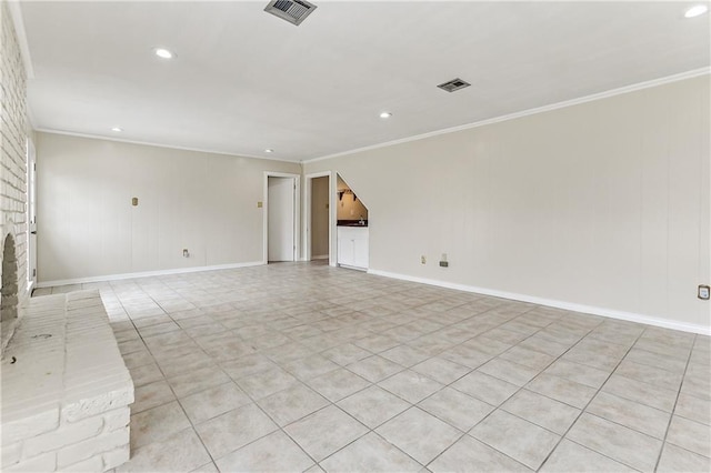 spare room featuring a fireplace, ornamental molding, and light tile patterned flooring