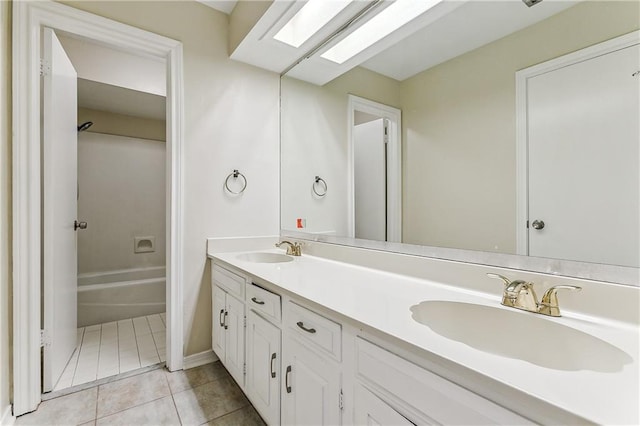 bathroom with tile patterned flooring, vanity, and a skylight