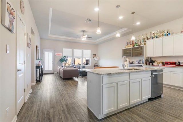 kitchen featuring white cabinets, sink, a kitchen island with sink, and a tray ceiling