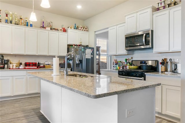 kitchen with white cabinetry, stainless steel appliances, and decorative light fixtures