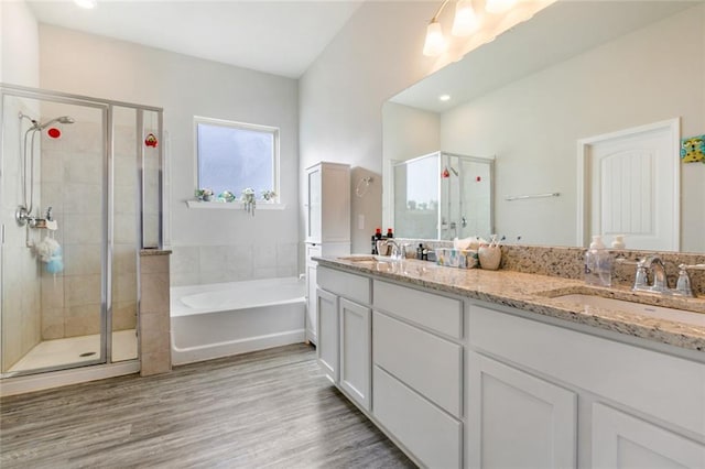 bathroom featuring hardwood / wood-style flooring, vanity, and plus walk in shower