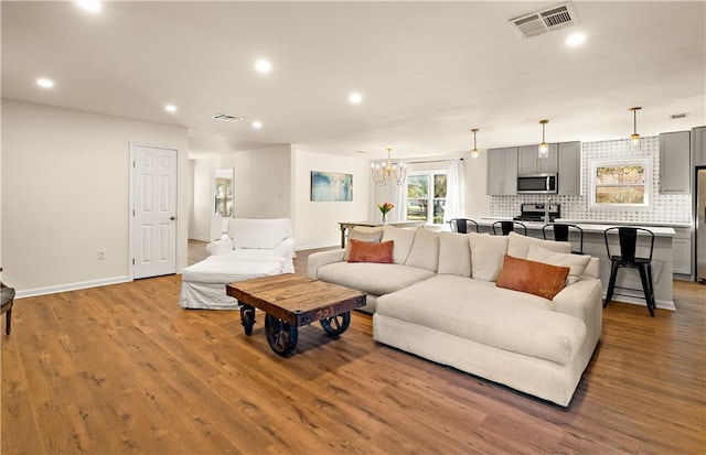 living room with light hardwood / wood-style flooring and a chandelier