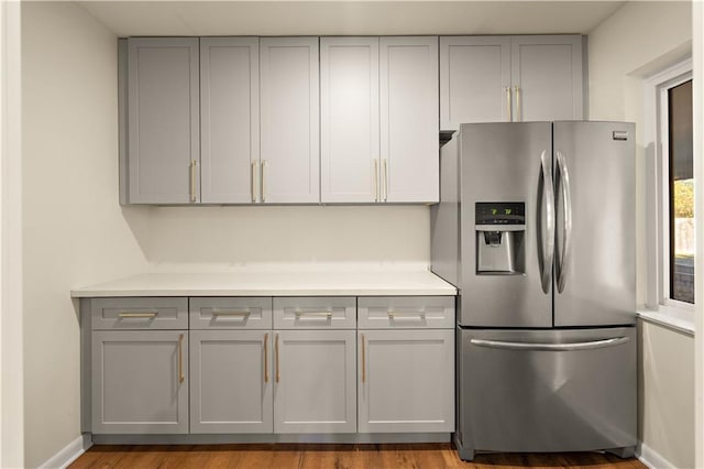 kitchen featuring stainless steel fridge, gray cabinets, and hardwood / wood-style floors