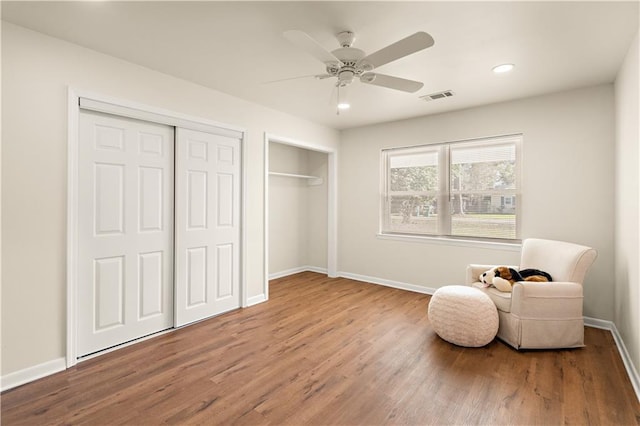 living area with ceiling fan and hardwood / wood-style flooring