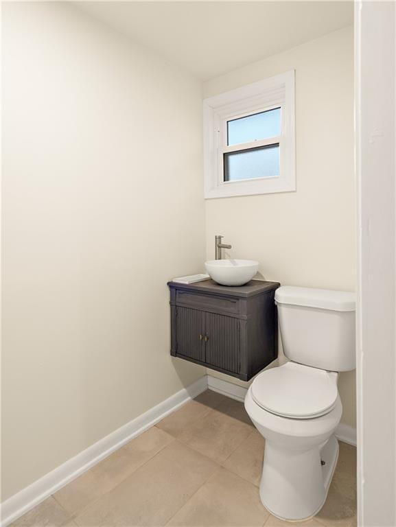 bathroom with tile patterned flooring, vanity, and toilet