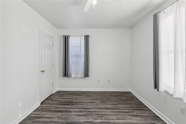 spare room featuring ceiling fan, a healthy amount of sunlight, and dark hardwood / wood-style flooring