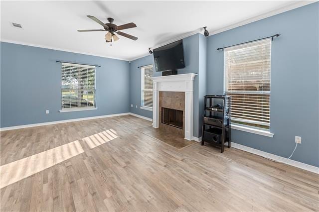 unfurnished living room featuring ceiling fan, wood-type flooring, and ornamental molding