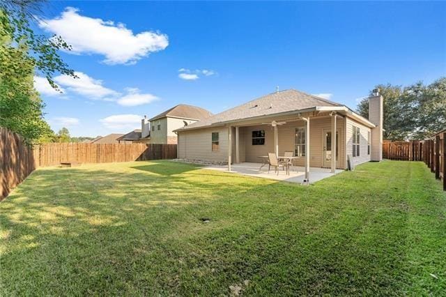 rear view of property with a patio area and a yard