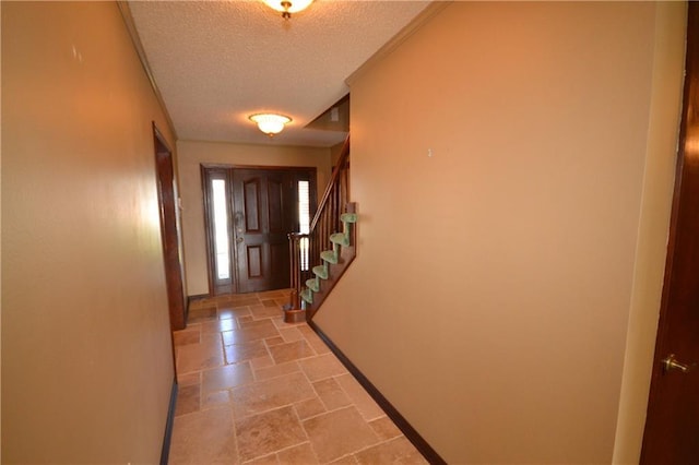 doorway to outside with a textured ceiling