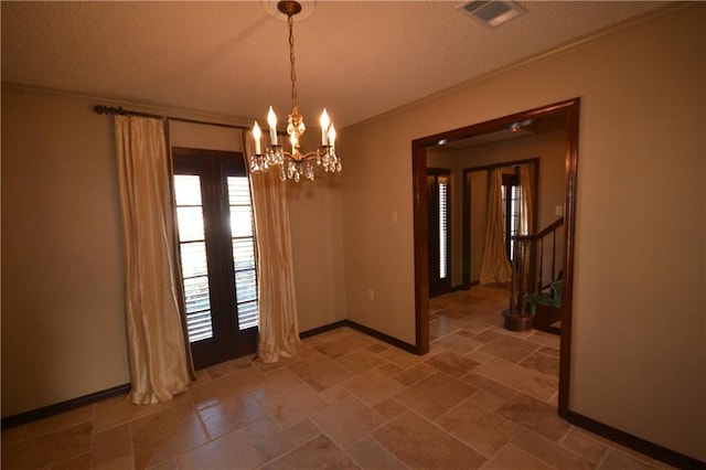 unfurnished dining area with a notable chandelier, crown molding, and a textured ceiling