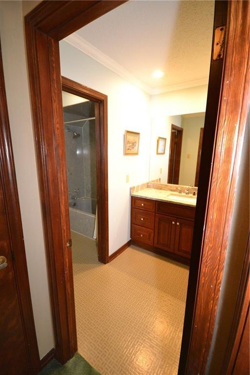 bathroom featuring vanity, shower / bathtub combination, and ornamental molding