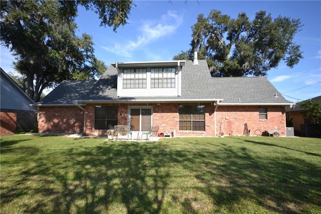 rear view of property featuring a yard and central AC