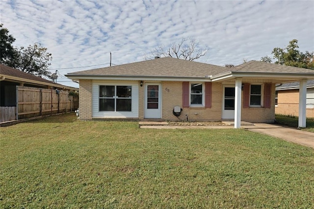 back of property featuring a carport and a lawn