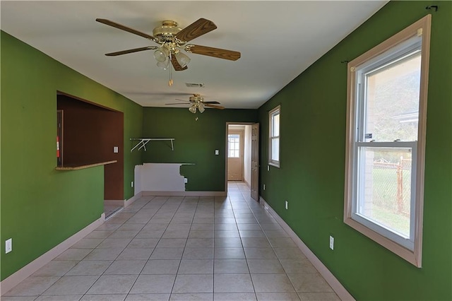 tiled spare room featuring ceiling fan