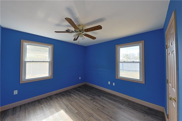 empty room with wood-type flooring, ceiling fan, and a healthy amount of sunlight