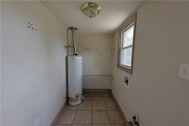 washroom with washer hookup, light tile patterned flooring, and gas water heater