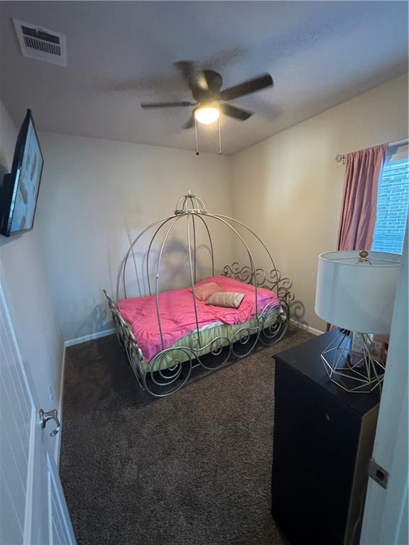 carpeted bedroom with visible vents and ceiling fan