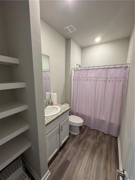 bathroom featuring visible vents, curtained shower, toilet, wood finished floors, and vanity