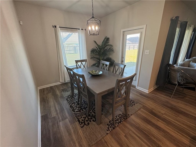 dining room featuring a chandelier, baseboards, and dark wood-style floors