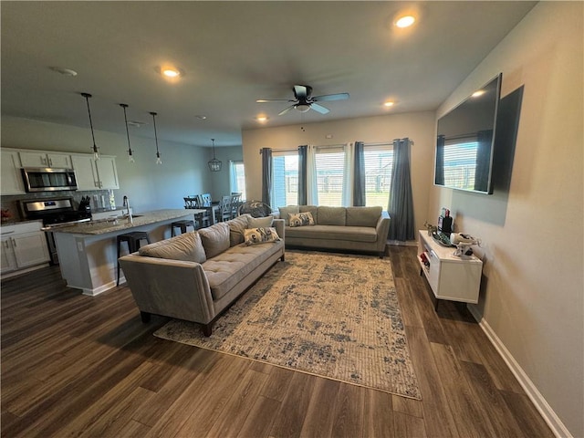 living area with dark wood finished floors, recessed lighting, baseboards, and ceiling fan