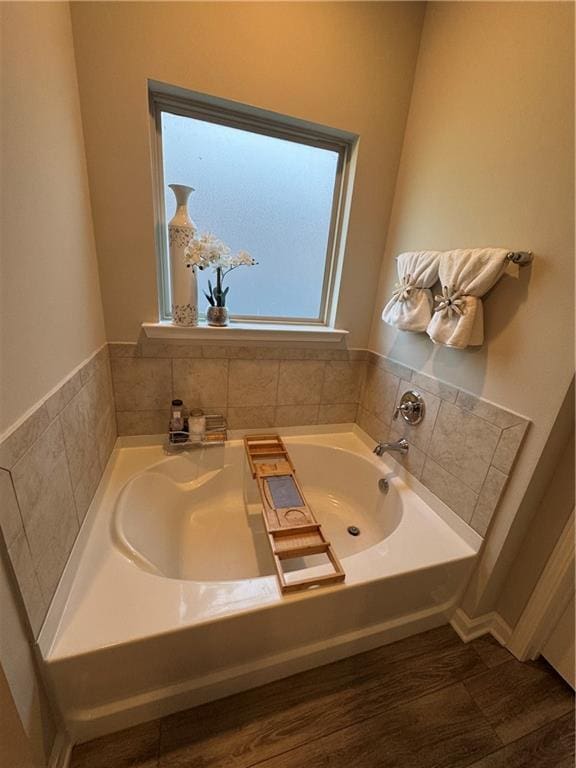 bathroom featuring a bath and wood finished floors