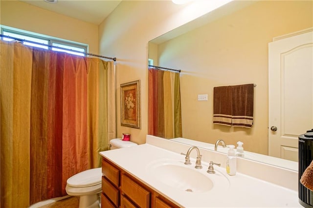 bathroom with a shower with shower curtain, vanity, and toilet