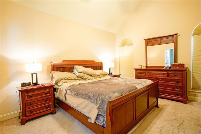 carpeted bedroom with lofted ceiling