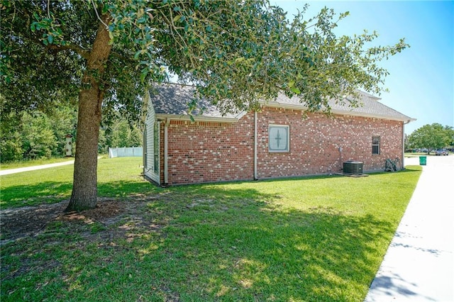 view of side of home with cooling unit and a lawn