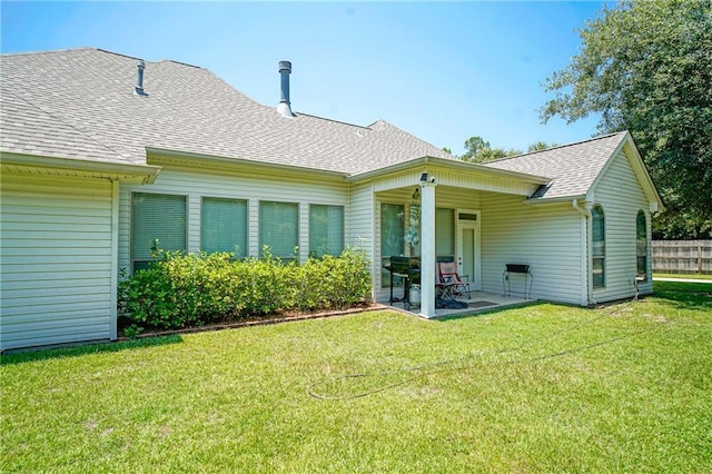 back of house with a yard and a patio