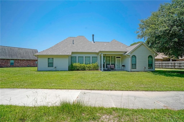 rear view of property featuring a lawn