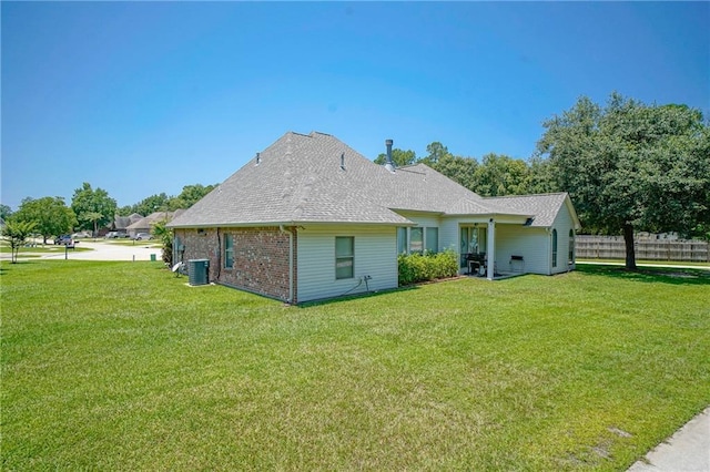 rear view of property with a yard and central air condition unit