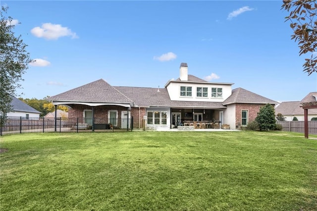 rear view of property featuring a patio area and a lawn