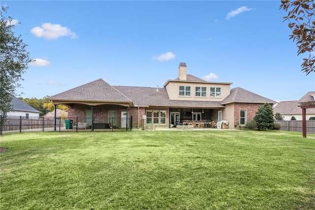 rear view of house featuring a lawn and a patio