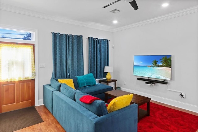 living room featuring hardwood / wood-style flooring, ceiling fan, and crown molding