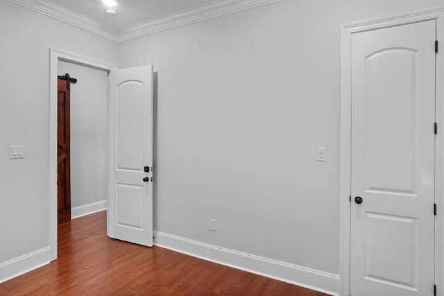 spare room featuring hardwood / wood-style floors and crown molding