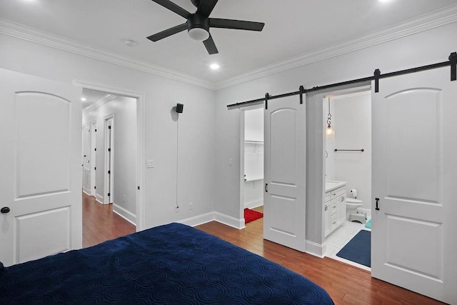 1519-21 N Villere St, New Orleans, LA 70116 - unfurnished bedroom featuring a barn door, wood finished floors, ornamental molding, recessed lighting, and connected bathroom