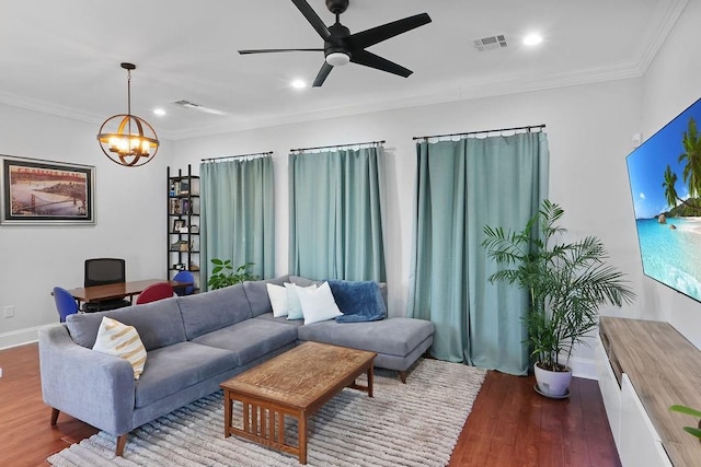 living room featuring hardwood / wood-style floors, ceiling fan with notable chandelier, and ornamental molding